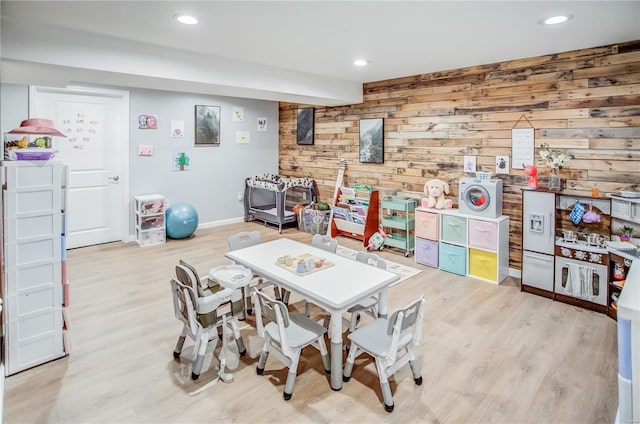 rec room with wooden walls, light wood-type flooring, recessed lighting, and baseboards