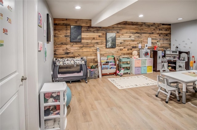 rec room featuring wood walls, wood finished floors, and recessed lighting