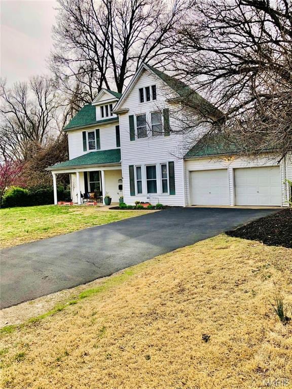 3579 Boswell, St John, MO 63114 - view of front of house with asphalt driveway, a front lawn, an attached garage, and a porch