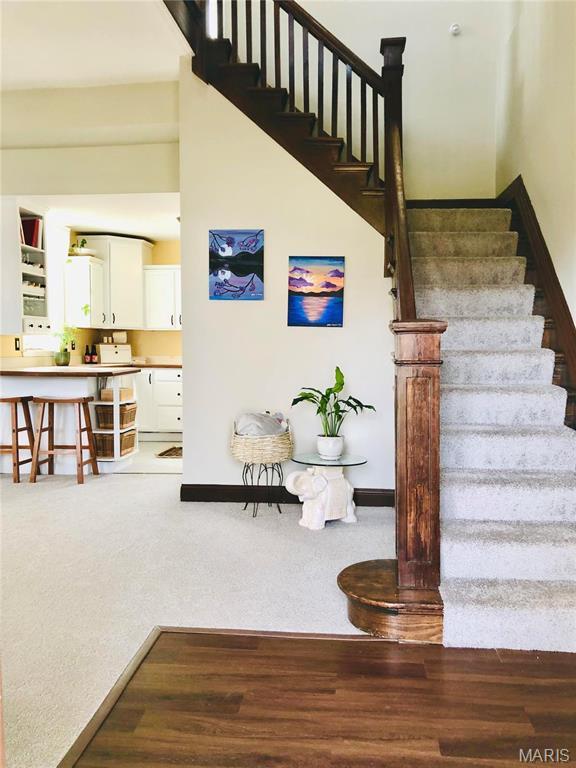 3579 Boswell, St John, MO 63114 - stairway with baseboards, wood finished floors, and carpet