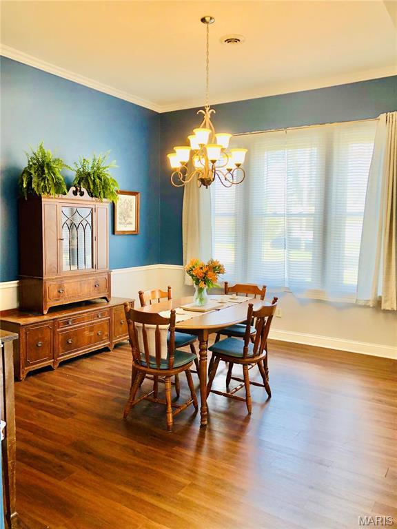 3579 Boswell, St John, MO 63114 - dining space with a chandelier, ornamental molding, dark wood-style floors, and baseboards