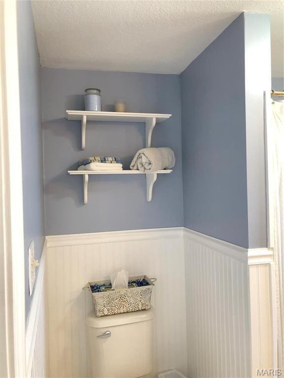 3579 Boswell, St John, MO 63114 - bathroom featuring wainscoting, toilet, and a textured ceiling