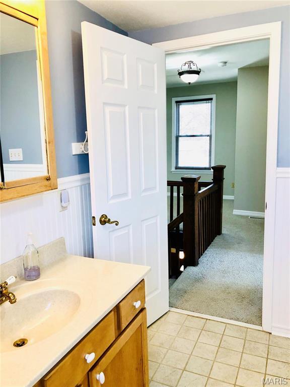 3579 Boswell, St John, MO 63114 - bathroom featuring a wainscoted wall, vanity, and tile patterned floors