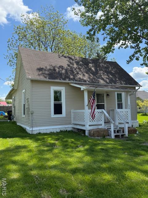 view of front of property with a porch, a front yard, and roof with shingles