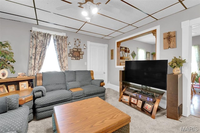living room featuring carpet, a paneled ceiling, and a ceiling fan