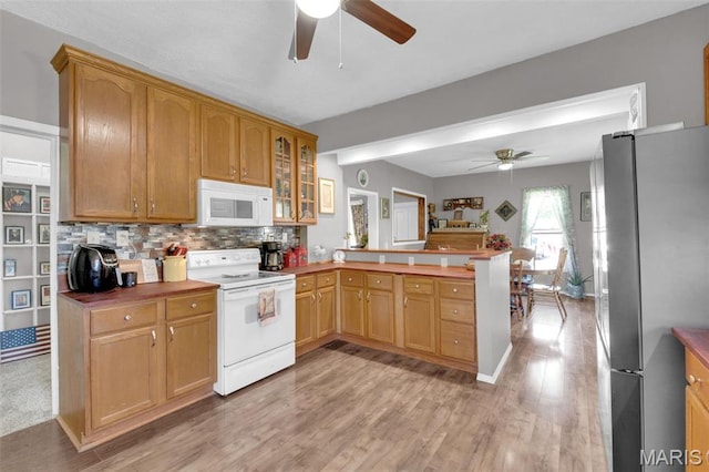 kitchen with white appliances, a ceiling fan, a peninsula, and light wood finished floors