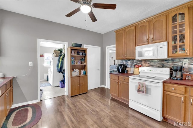 kitchen with white appliances, ceiling fan, backsplash, and glass insert cabinets