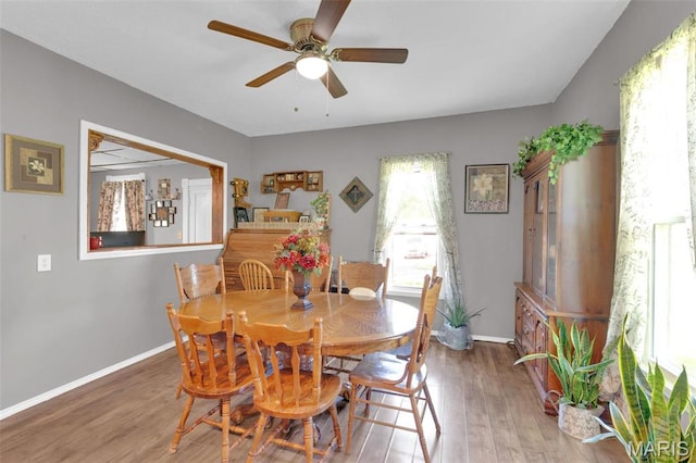 dining space with wood finished floors, ceiling fan, and baseboards