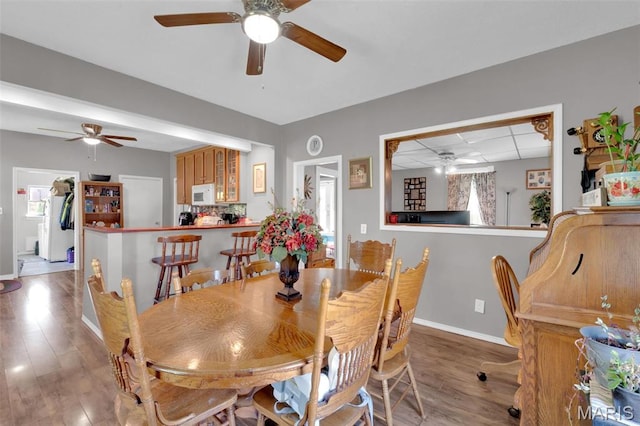 dining room with a ceiling fan, baseboards, and wood finished floors