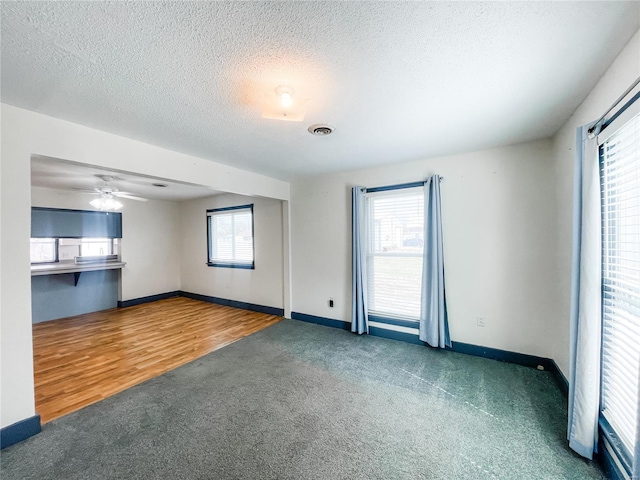 791 E Adams St, Nashville, IL 62263 - unfurnished living room featuring carpet floors, plenty of natural light, baseboards, a textured ceiling, and ceiling fan