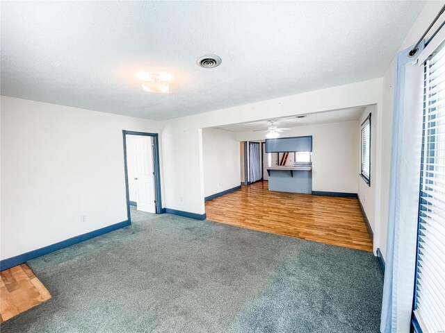 791 E Adams St, Nashville, IL 62263 - unfurnished living room featuring carpet flooring, a ceiling fan, baseboards, and a textured ceiling