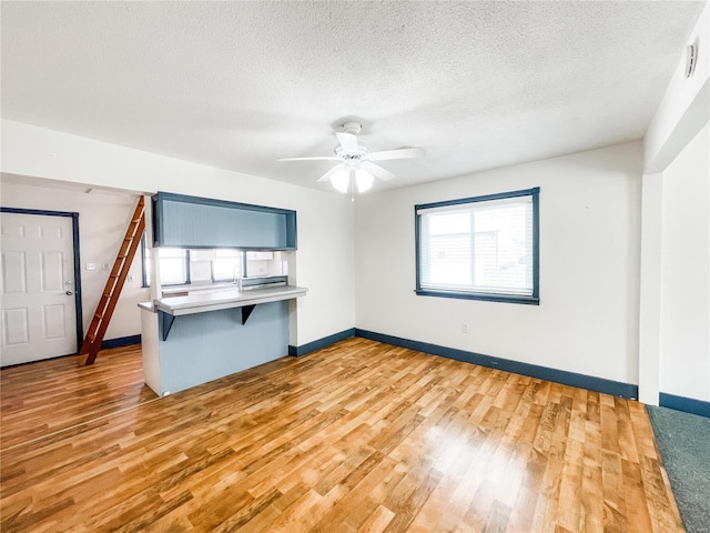 791 E Adams St, Nashville, IL 62263 - empty room with light wood-type flooring, a ceiling fan, a textured ceiling, and baseboards