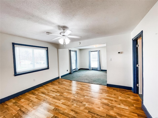 791 E Adams St, Nashville, IL 62263 - unfurnished room with light wood-type flooring, ceiling fan, baseboards, and a textured ceiling