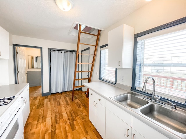 791 E Adams St, Nashville, IL 62263 - kitchen featuring gas range gas stove, a sink, light wood-style floors, white cabinets, and light countertops