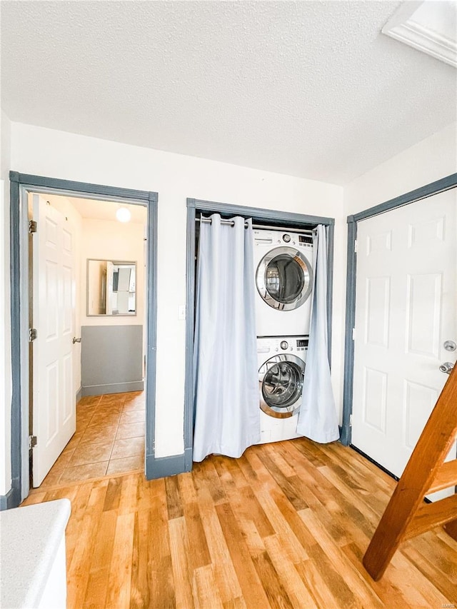 791 E Adams St, Nashville, IL 62263 - laundry room with stacked washer and clothes dryer, light wood-style floors, and a textured ceiling