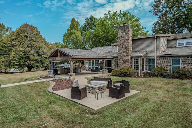 rear view of house with a patio, a chimney, a jacuzzi, a yard, and brick siding