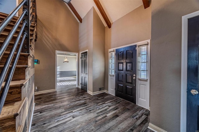 entryway featuring dark wood finished floors, high vaulted ceiling, baseboards, stairs, and a textured wall