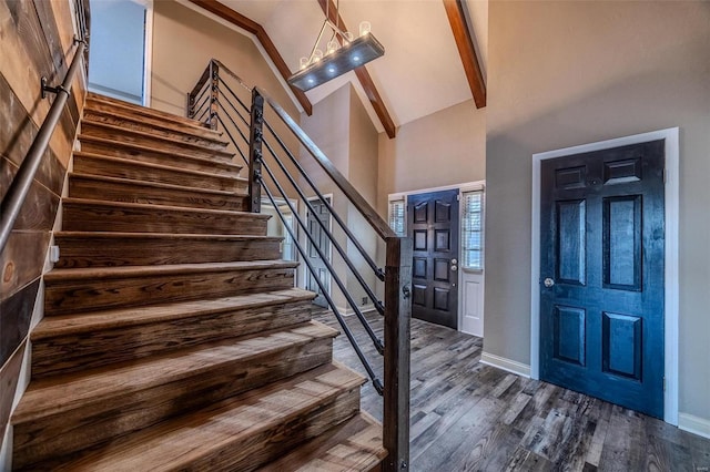 staircase featuring high vaulted ceiling, wood finished floors, beam ceiling, and baseboards