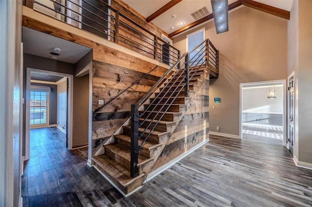 stairs featuring baseboards, wood finished floors, high vaulted ceiling, and beamed ceiling