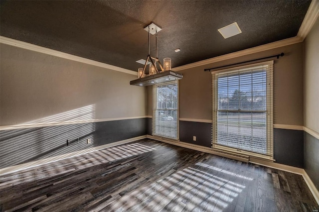 unfurnished dining area with crown molding, baseboards, wood finished floors, and a textured ceiling