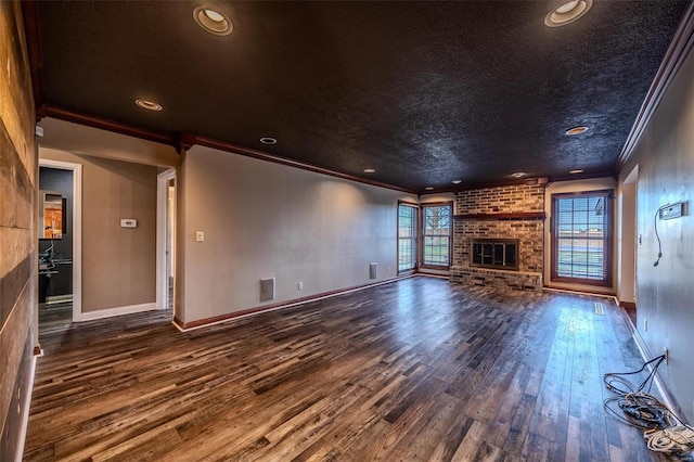 unfurnished living room with ornamental molding, hardwood / wood-style floors, baseboards, a brick fireplace, and recessed lighting