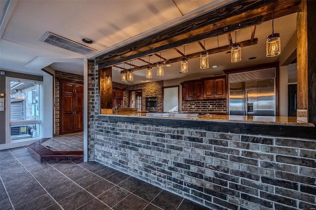 bar area with appliances with stainless steel finishes, brick wall, dark tile patterned floors, and hanging light fixtures