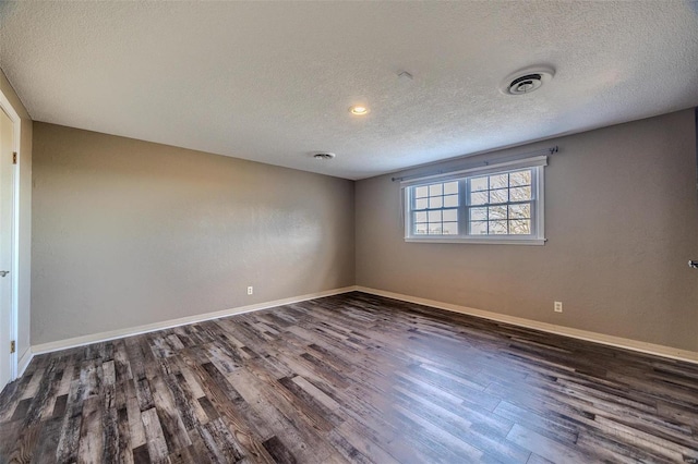 empty room with a textured ceiling, wood finished floors, baseboards, and recessed lighting