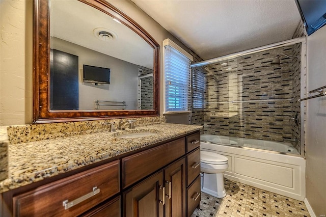 full bathroom with toilet, bath / shower combo with glass door, vanity, and tile patterned floors
