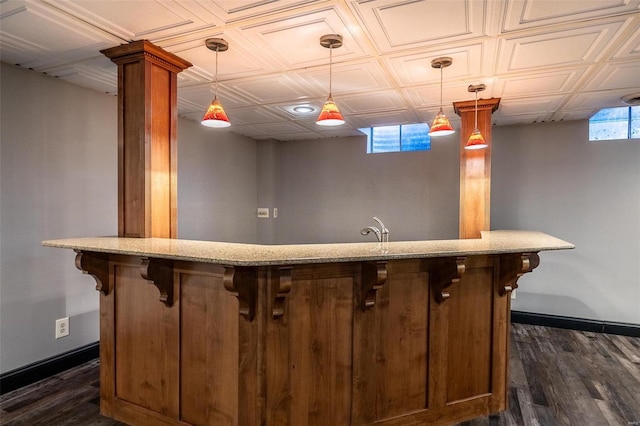 bar area with dark wood-style floors, baseboards, and hanging light fixtures