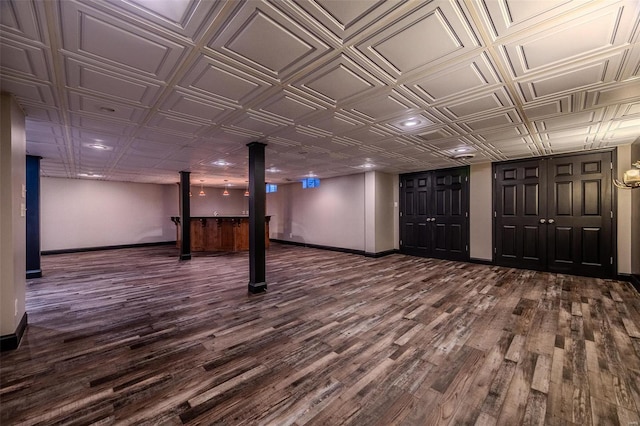 finished basement featuring dark wood-type flooring, baseboards, an ornate ceiling, and recessed lighting