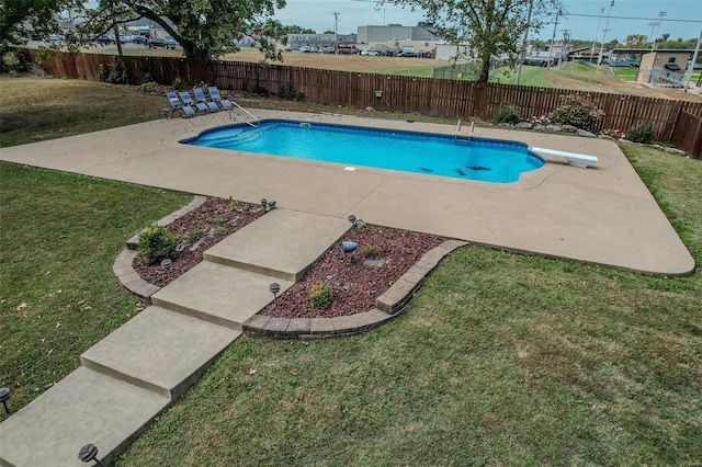 view of pool with a patio area, a diving board, and a residential view