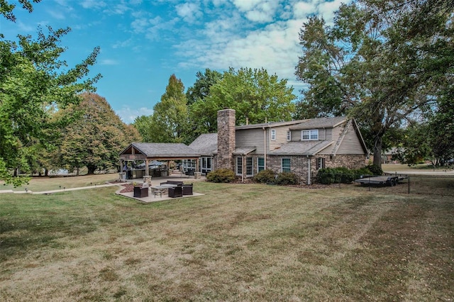 rear view of property featuring a patio area, a chimney, and a lawn