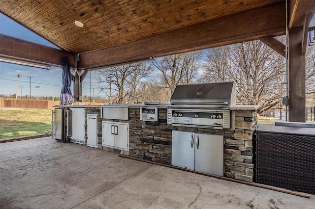 view of patio / terrace featuring a grill, exterior kitchen, and fence
