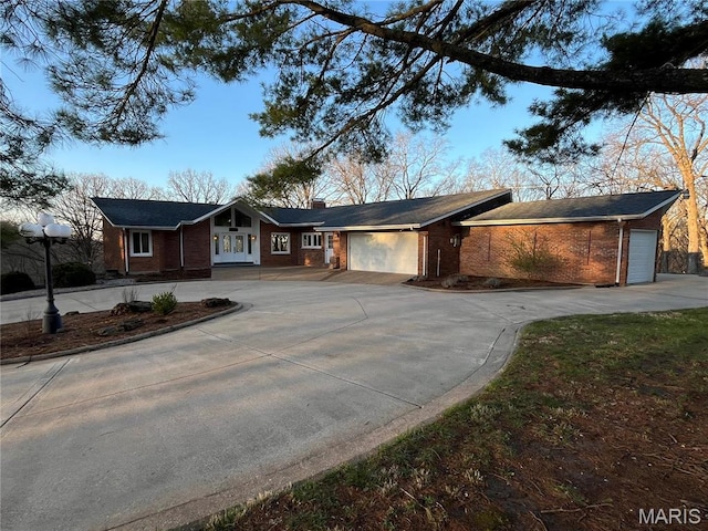 view of front facade with brick siding, concrete driveway, and a garage