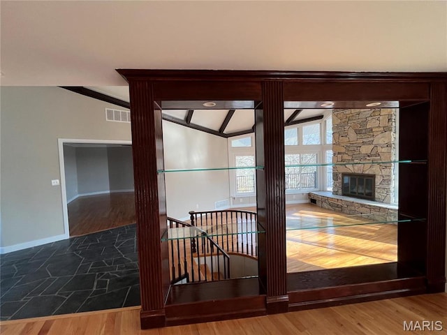 detailed view of baseboards, a fireplace, and wood finished floors