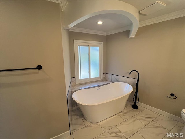 bathroom featuring ornamental molding, a freestanding tub, marble finish floors, baseboards, and recessed lighting