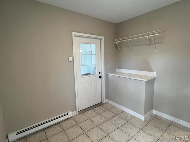 doorway to outside featuring baseboard heating, light tile patterned flooring, and baseboards