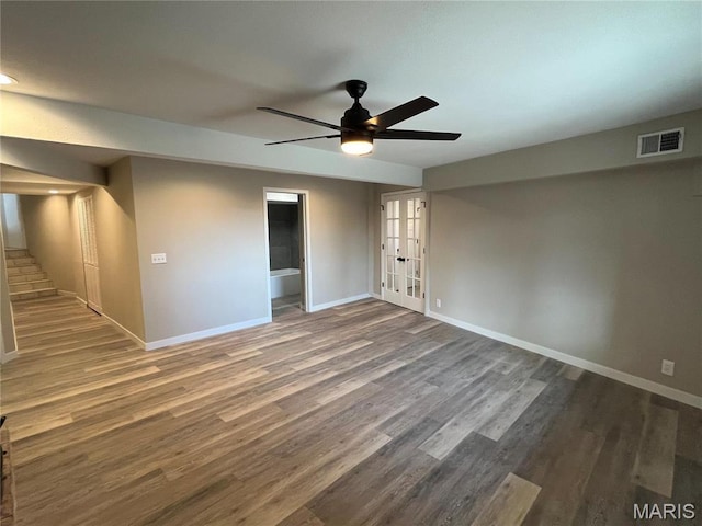 empty room featuring baseboards, french doors, wood finished floors, and a ceiling fan