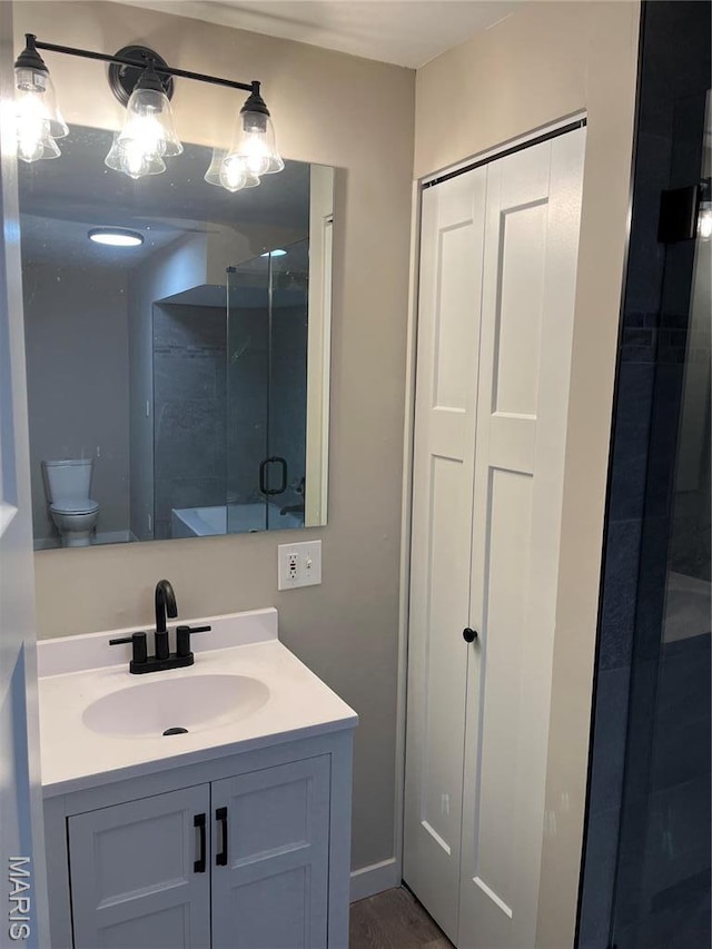 bathroom with vanity, toilet, and an enclosed shower