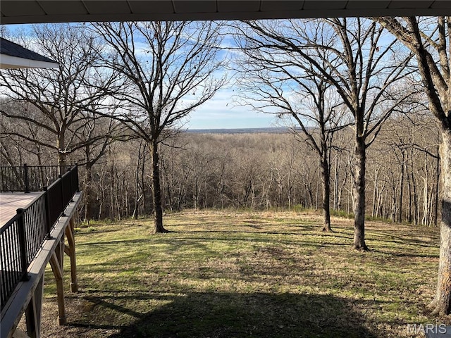 view of green lawn with a view of trees