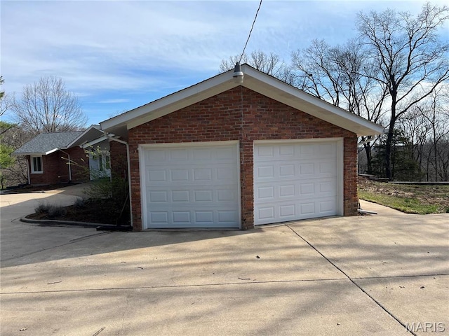 garage featuring concrete driveway