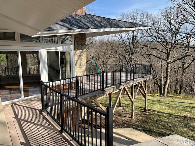 deck featuring a playground and a lawn