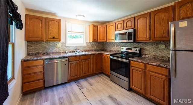 290 E Oak St, Saint Clair, MO 63077 - kitchen featuring appliances with stainless steel finishes, a sink, light wood-type flooring, and brown cabinetry