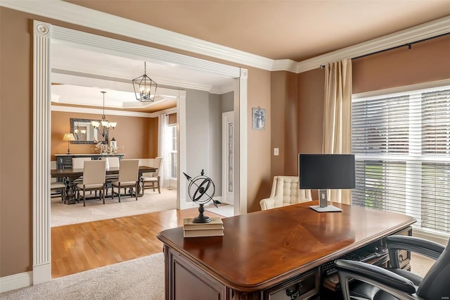 office space featuring light wood-style floors, a chandelier, crown molding, and baseboards