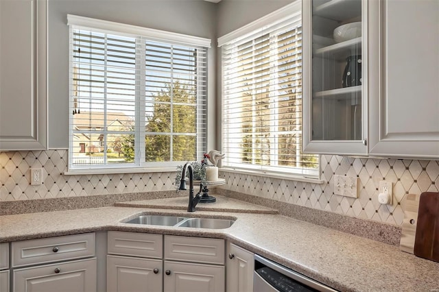 kitchen featuring a sink, light countertops, white cabinetry, and backsplash
