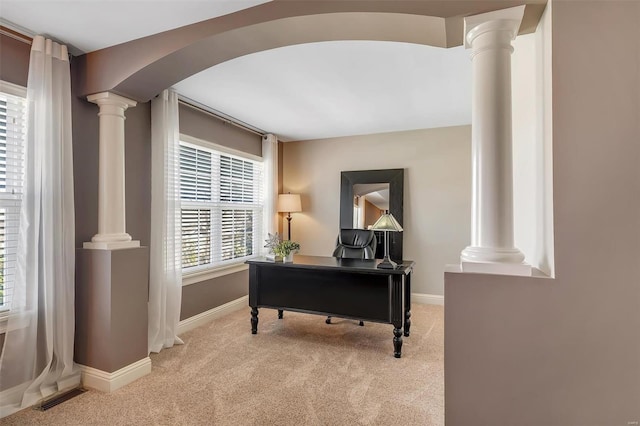 office with ornate columns, carpet floors, arched walkways, and baseboards
