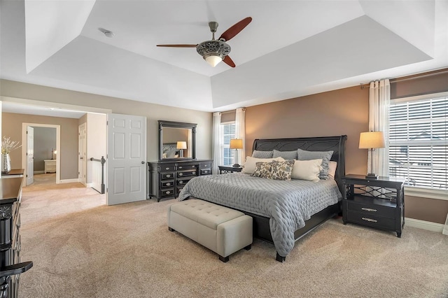 bedroom with carpet floors, baseboards, ceiling fan, and a raised ceiling