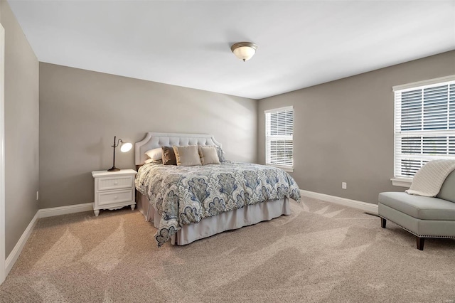 bedroom featuring light carpet and baseboards