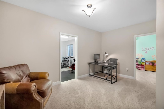 sitting room with a desk, carpet floors, and baseboards
