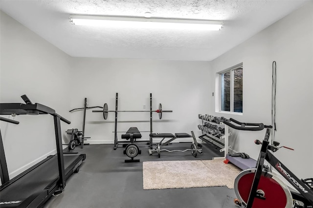 exercise area featuring a textured ceiling and baseboards